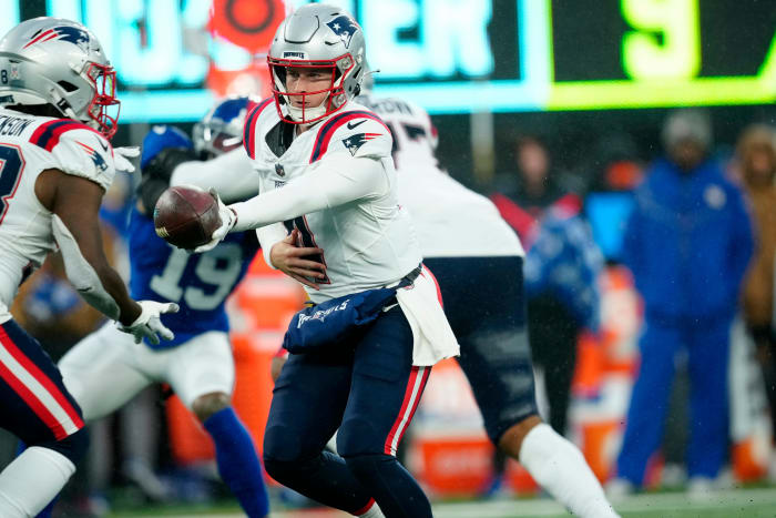 New England Patriots quarterback Bailey Zappe (4) prepares to handoff to New England Patriots running back Rhamondre Stevenson (38)